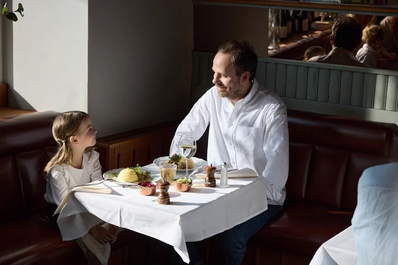 Gäster vid ett dukat bord i en restaurang